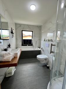 La salle de bains est pourvue d'une baignoire, d'un lavabo et de toilettes. dans l'établissement JUNIPRO Hotel Schinderhannes, à Weiskirchen