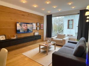 a living room with a couch and a tv on a wall at Bebek Parkına Bakan Daire in Istanbul