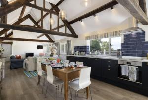 uma cozinha e sala de jantar com uma mesa de madeira e cadeiras em Long Barn em Coates