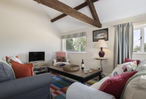 Long Barn في Coates: غرفة معيشة مع أريكة وطاولة