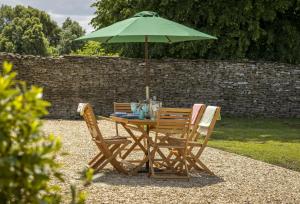 a table with two chairs and an umbrella at Long Barn in Coates