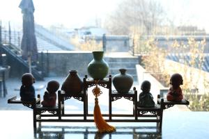a group of figurines sitting on a shelf with vases at Beijing Unified Courtyard Hotel in Beijing