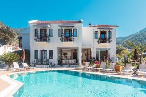 a villa with a swimming pool in front of a house at Bronze Hotel in Oludeniz