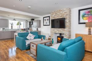 a living room with two blue chairs and a fireplace at Stunning 1-Bed Cottage near Carlisle with Hot tub in Carlisle