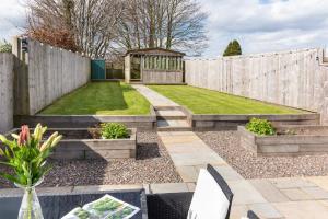 a garden with a wooden fence and a gazebo at Stunning 1-Bed Cottage near Carlisle with Hot tub in Carlisle