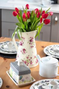 a vase filled with red flowers sitting on a table at Cottage - Sleeps 3 hot tub & pet friendly in Carlisle