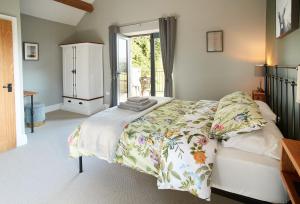 1 Schlafzimmer mit einem Bett mit Blumenbettdecke in der Unterkunft The Old Buttress at Rotherhope Towers in Alston