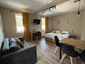 Zimmer mit einem Bett, einem Sofa und einem Tisch in der Unterkunft Krollhouse Pokoje gościnne in Wolbrom