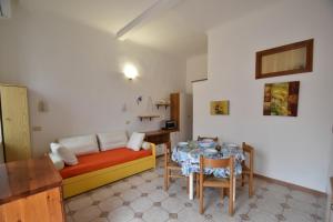 a living room with a couch and a table at Bilocali ALTAMAREA - zona mare con clima e terrazze in Marina di Campo