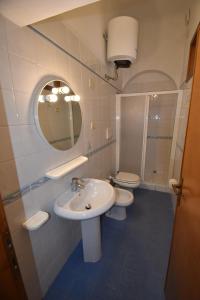 a bathroom with two toilets and a sink and a mirror at Bilocali ALTAMAREA - zona mare con clima e terrazze in Marina di Campo +43 photos