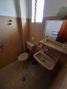 uma casa de banho com um WC, um lavatório e um espelho. em Alexandra Studio 6 em Lefkimmi