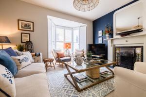 a living room with a couch and a fireplace at Chart House 10 Guests in Tenby