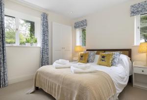 a bedroom with a bed with two towels on it at Cats Abbey Cottage in Northleach