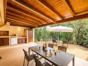 patio con tavolo, sedie e ombrellone di House Adele - Cala Sinzias a Villasimius