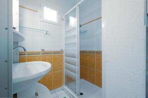 een badkamer met een wastafel en een glazen douche bij Rêve De Mer - Appartement 6 in Frontignan