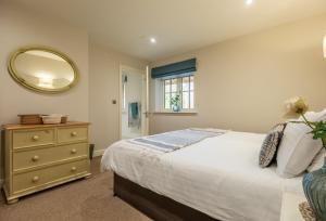 a bedroom with a bed and a mirror at Stables Cottage in Tilton