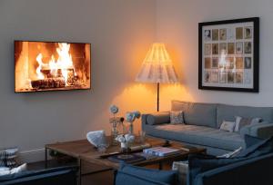 a living room with a couch and a fireplace at Missy's House in the Woods in Harringworth