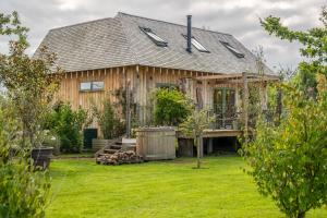 a wooden house with a yard at Olive Tree House in Chalvington