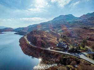 an aerial view of a mountain with a road and water at Bryn Elltyd Eco House in Blaenau-Ffestiniog