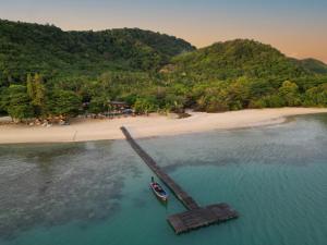 a boat in the water next to a beach at Cruiser Island By Swiss-Belhotel in Ko Lone