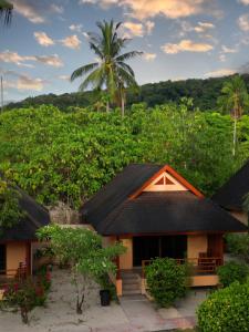 a house in front of a hill with trees at Cruiser Island By Swiss-Belhotel in Ko Lone