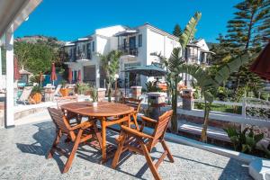 uma mesa de madeira e cadeiras num pátio em Bronze Hotel em Oludeniz