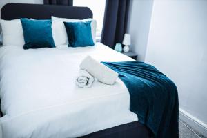 a white bed with a towel on top of it at Sapphire Apartment Leicester in Leicester