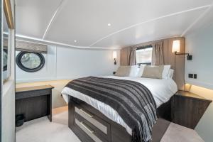 JOIVY Elegant houseboat near Canary Wharf في لندن: غرفة نوم بسرير كبير بقارب