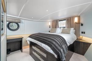 - une chambre avec un grand lit dans un bateau dans l'établissement ALTIDO Elegant houseboat near Canary Wharf, à Londres