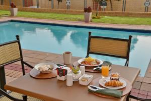 a table with food and drinks next to a pool at Road Lodge Southgate in Southgate