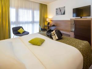 a hotel room with a bed and a television at Hotel Mercure Graz City in Graz