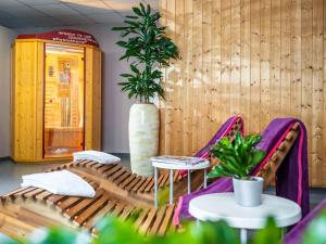 a room with a couch and two chairs and a plant at Hotel Mercure Graz City in Graz