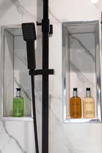 a bathroom with two shelves with two bottles of soap at Ideal Lodgings In Audenshaw in Manchester