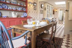 a dining room with a wooden table and chairs at Beau Repaire in Coneysthorpe