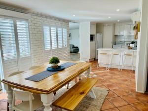a dining room and kitchen with a wooden table and chairs at Mooloolaba Waterfront Unit - sleeps 8 in Mooloolaba