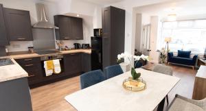 uma cozinha e sala de estar com mesa e cadeiras em Ideal Lodgings In Audenshaw em Manchester