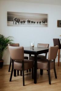 a dining room table with chairs and a picture of elephants at Welcome Haus Allgäu in Memmingen