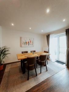 a dining room with a wooden table and chairs at Welcome Haus Allgäu in Memmingen