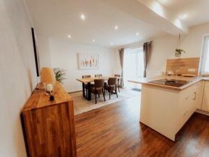 a kitchen and living room with a table and a dining room at Welcome Haus Allgäu in Memmingen