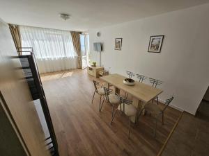 a dining room with a wooden table and chairs at Apartment Fort Noks in Sveti Vlas