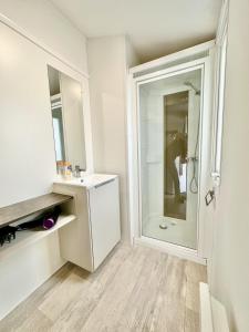 baño blanco con ducha y lavamanos en Bungalow 3 chambres pour 6 pers avec Climatisation Camping 3 etoiles en Samoëns
