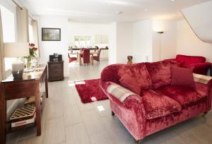 een woonkamer met een rode bank en een tafel bij Wisteria Cottage Ceredigion in Ystrad Meurig