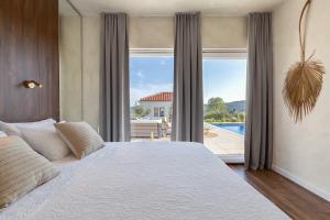sypialnia z dużym łóżkiem i dużym oknem w obiekcie Villa Nebesi ZadarVillas w mieście Pristeg +37 zdjęć