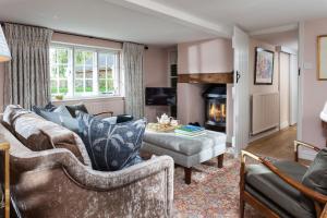 a living room with a couch and a fireplace at Wisteria Cottage in Urchfont