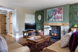 a living room with a couch and a fireplace at Radcot Bridge Cottage in Radcot