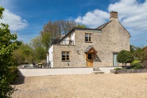 an exterior view of a stone house at Radcot Bridge Cottage in Radcot