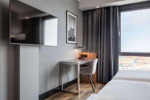 a hotel room with a desk and a bed and a window at Radisson Blu Scandinavia Hotel, Copenhagen in Copenhagen