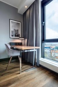 a desk and a chair in a room with a window at Radisson Blu Scandinavia Hotel, Copenhagen in Copenhagen