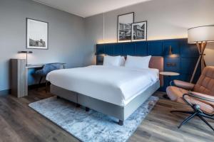 a bedroom with a large bed and a chair at Radisson Blu Scandinavia Hotel, Copenhagen in Copenhagen