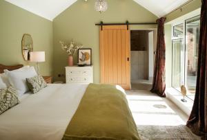 a bedroom with a large bed and a bathroom at Woodland Retreat in Burton upon Trent